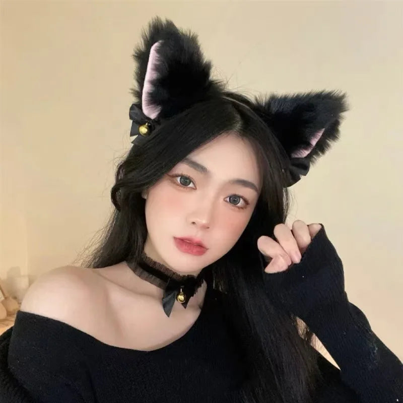 A woman wearing a black top and a kawaii cat ear headband with a bell choker set.