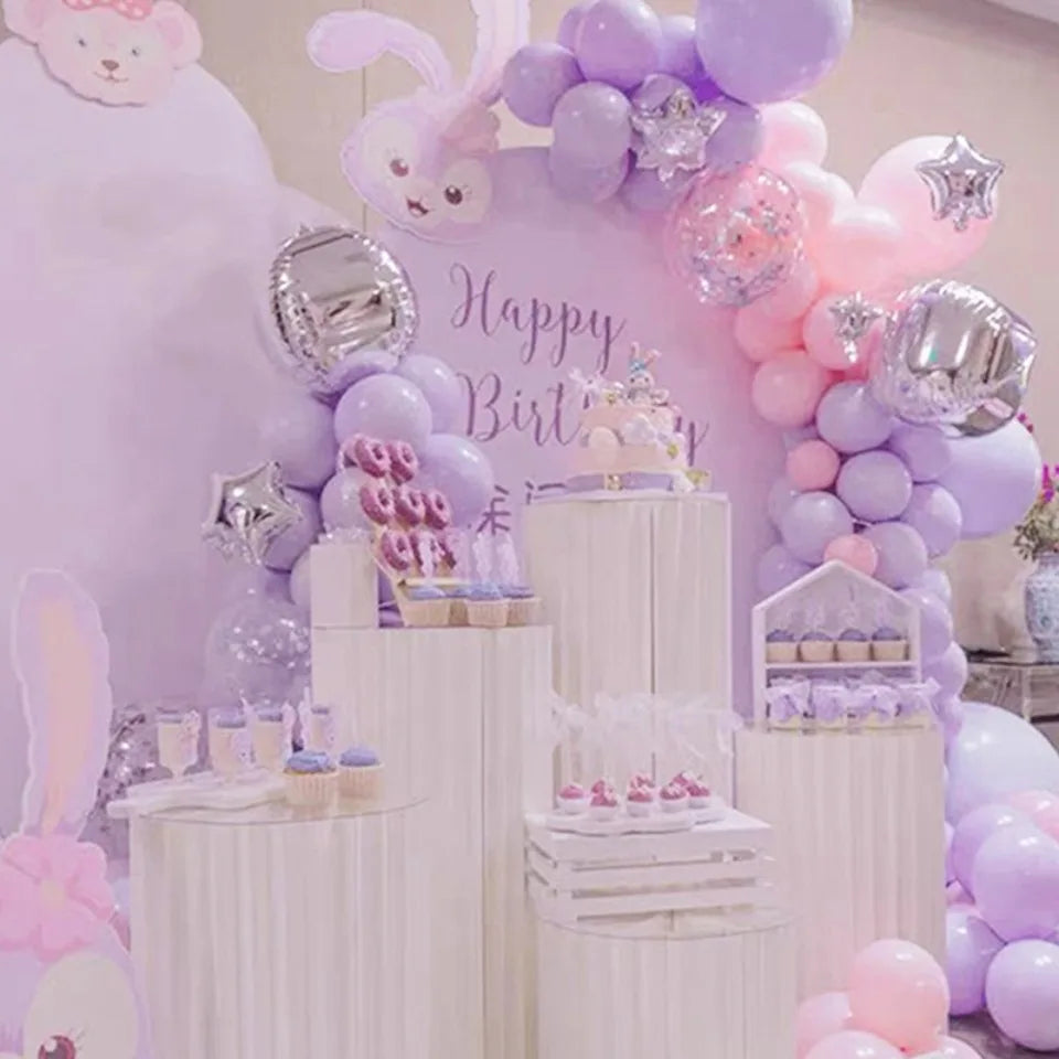 Arrière-plan de ballons violets et roses et présentoirs à gâteaux pour une fête d'anniversaire.