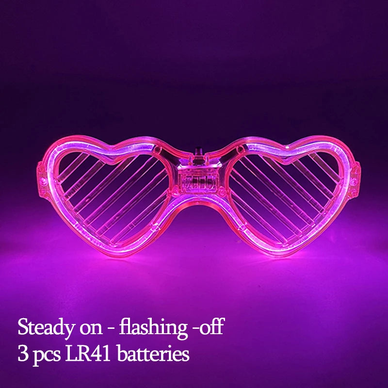 Pink herzförmige LED-Partybrille leuchtet hell vor lila Hintergrund