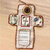 Handmade prayer quilt featuring a cross with decorative fabric elements and a silver cross pocket shrine.