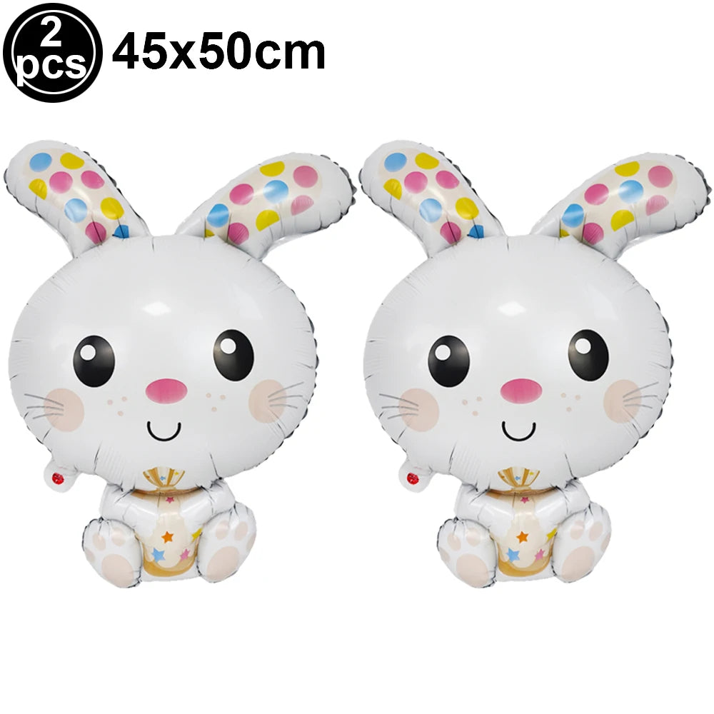 Two white cartoon bunny foil balloons with pink accents and gold crowns