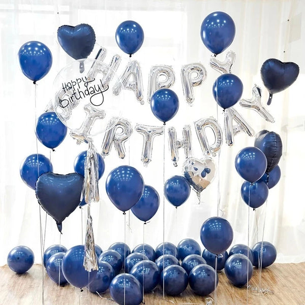 A cluster of blue latex balloons spelling out HAPPY BIRTHDAY with silver foil letters and heart shapes.