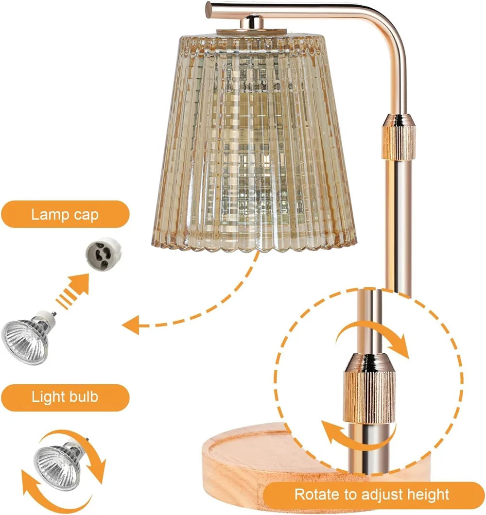 A modern adjustable electric candle warmer lamp with a clear glass shade and brass finish.