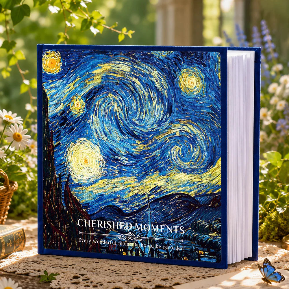 A blue photo album titled Cherished Moments featuring a night sky and landscape painting in a garden setting.