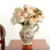 A bouquet of artificial champagne peony flowers in soft pink and cream tones displayed in a ceramic vase.