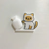 A white acrylic magnetic decor shaped like a cat with orange and white markings.