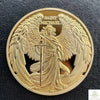 A gold souvenir coin featuring a relief of Saint Michael with wings and a spear.