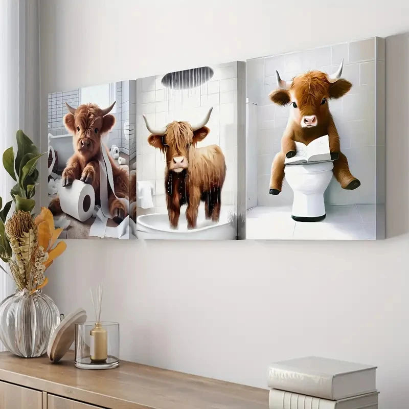 Wall art featuring three paintings of Highland cows, one standing on a toilet.