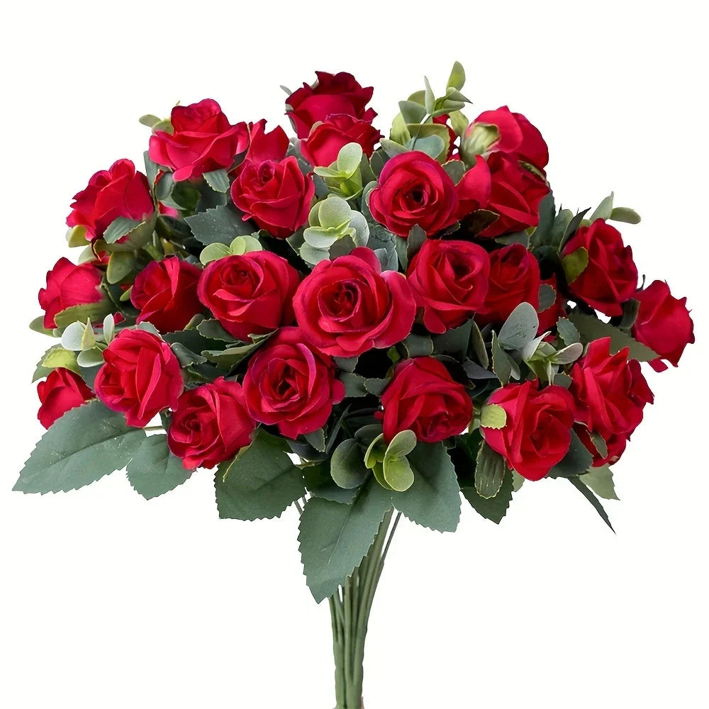 A bouquet of deep red silk roses and green eucalyptus leaves for wedding or home decor.