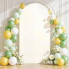 A white arched backdrop decorated with a garland of yellow and green balloons and white flowers.