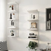 A white five-tier wall-mounted storage shelf displaying various decorative objects and books.