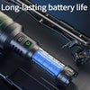 A close-up view of a rechargeable zoom flashlight with a glowing blue LED light inside, resting on a dark surface.
