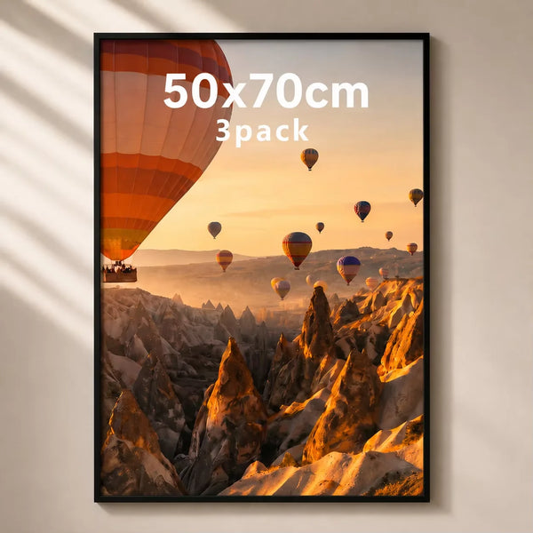 A framed photograph of a sunset landscape featuring numerous hot air balloons over rugged mountains.