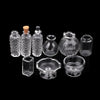 A set of miniature glass items including a vase and wine bottle, displayed against a black background.