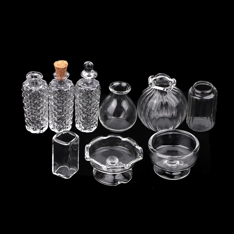 A set of miniature glass items including a vase and wine bottle, displayed against a black background.
