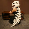 A person wearing a realistic dinosaur skeleton costume with a white skull headpiece and rib cage structure.