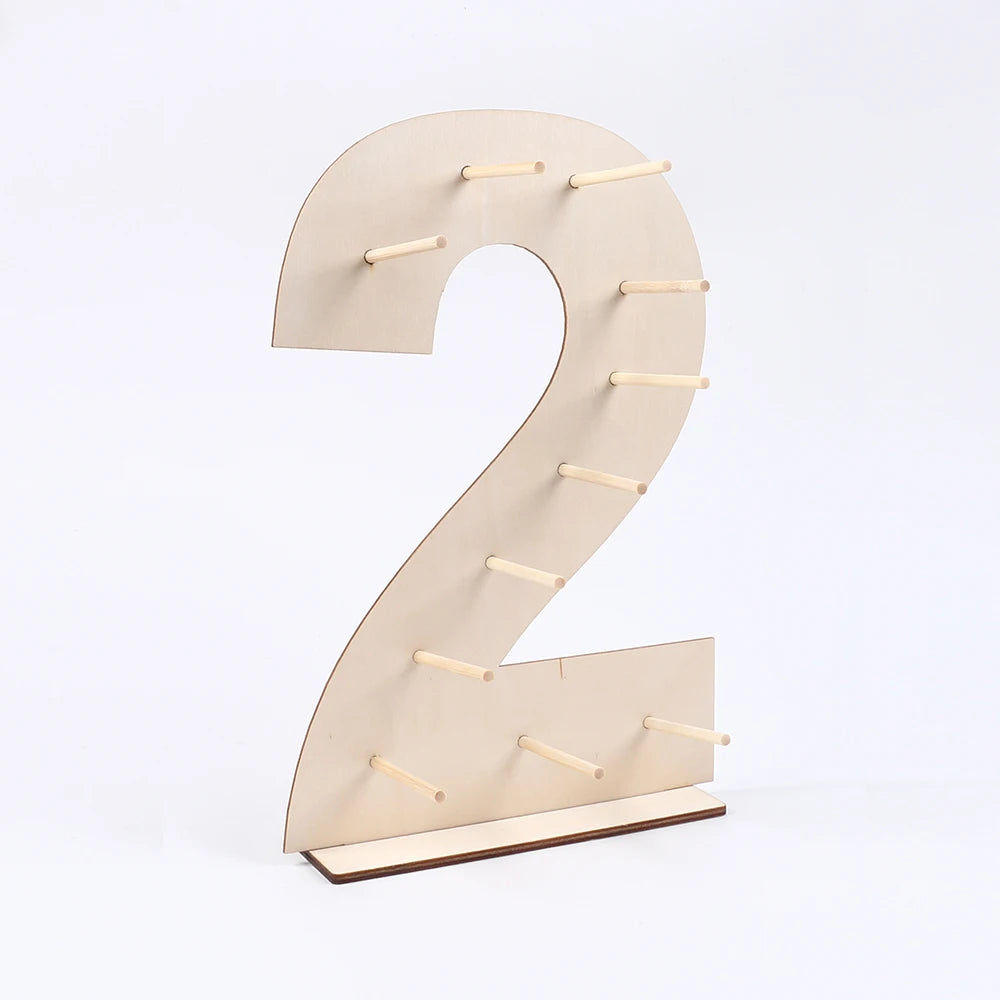 A light wood display stand shaped like the number two, featuring small wooden pegs for holding items.