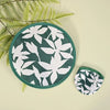 A circular, foldable cooling fan with a dark green fabric and white floral pattern is shown on a light background.