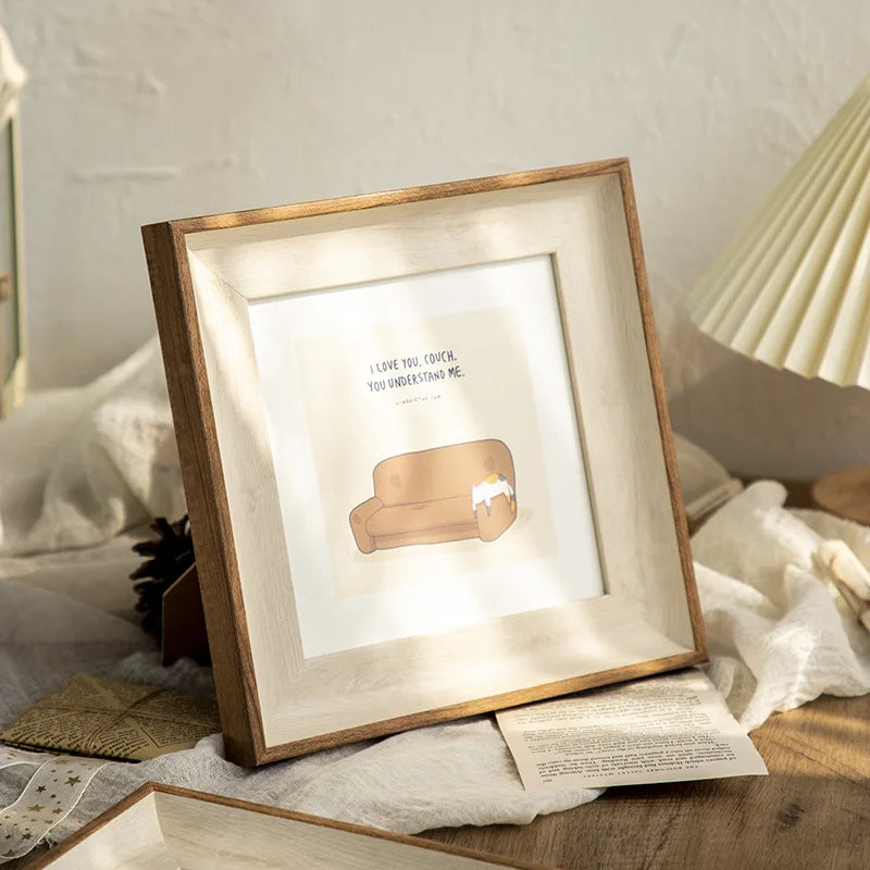A wooden photo frame with a light wood border displaying a quote on a neutral background.