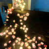 LED rattan string lights with pink and orange flowers decorating a dark leather sofa.