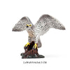 Realistic figurine of an owl with yellow eyes perched on a dark base.