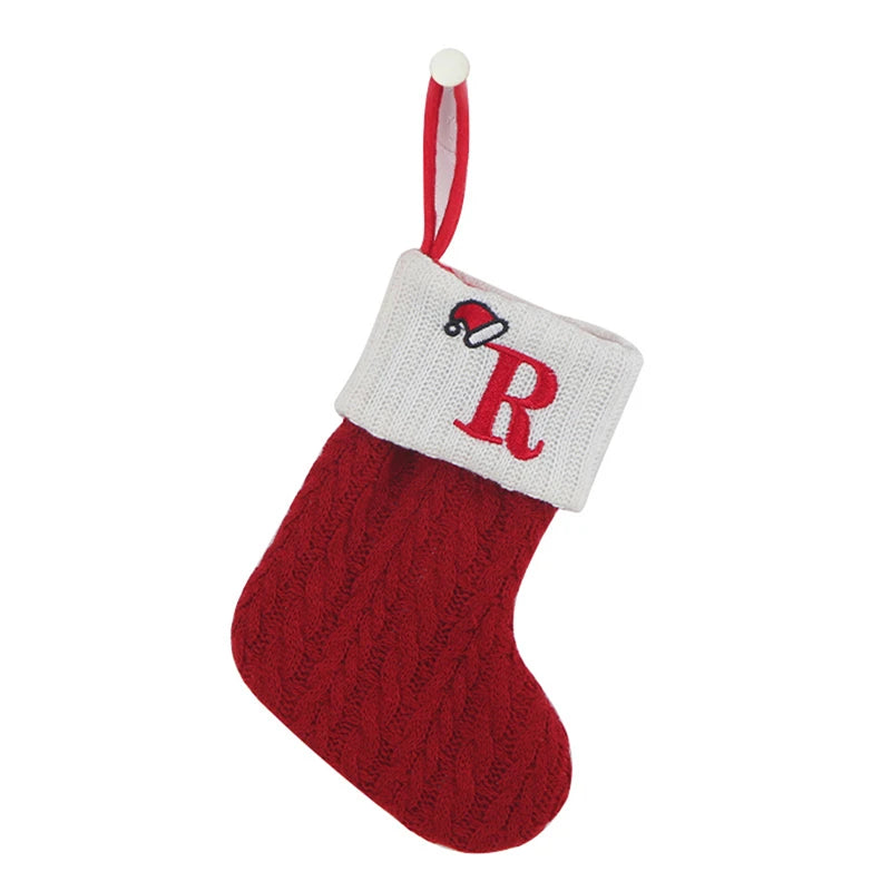 Red knitted sock with a white alphabet letter R and a pom-pom topper for Christmas tree decoration