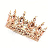 A delicate gold crystal rhinestone crown cake topper with pink accents.