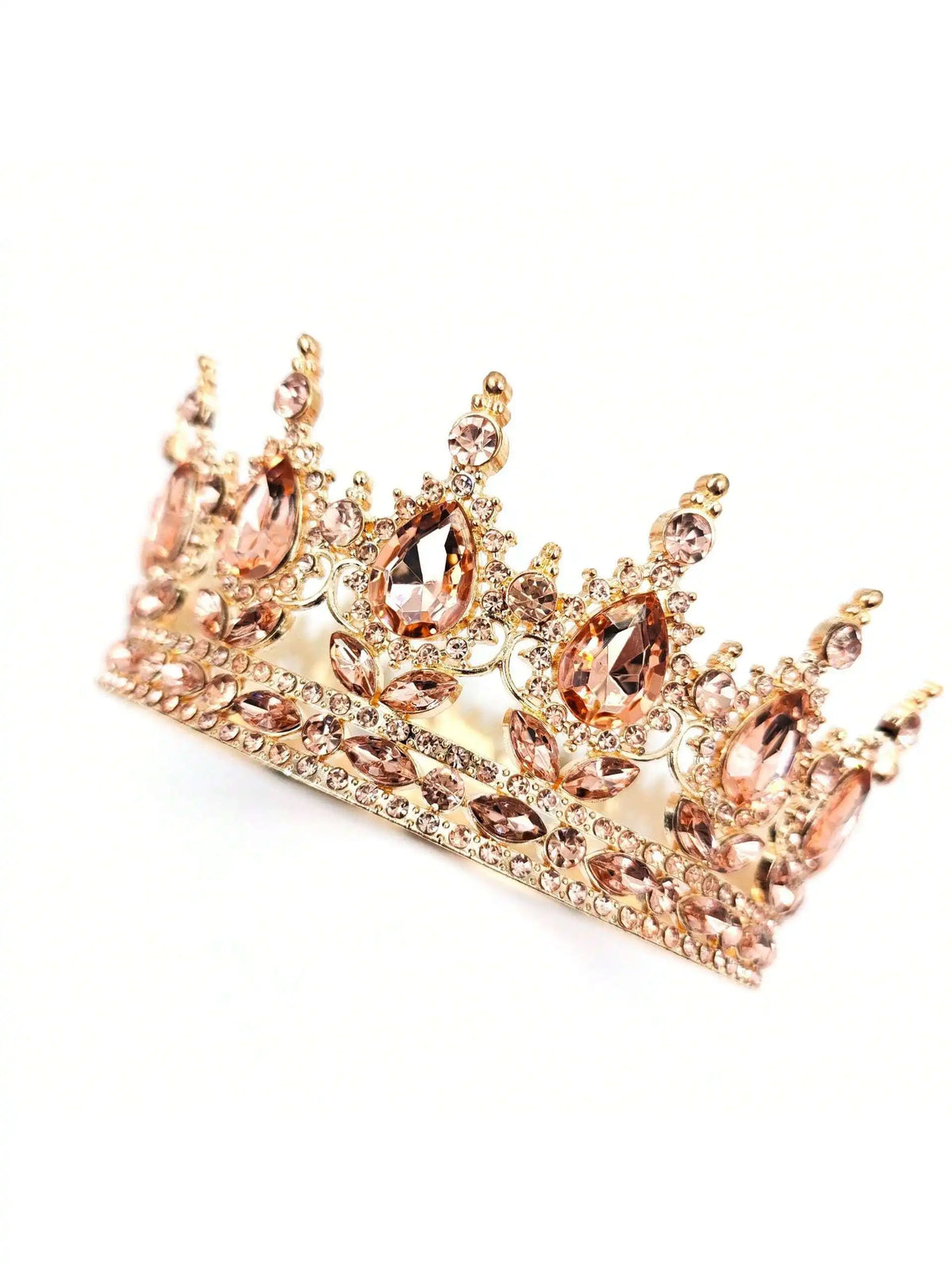 A delicate gold crystal rhinestone crown cake topper with pink accents.