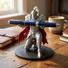 A 3D printed silver knight figure holding a blue pen, standing on a dark base on a wooden table.