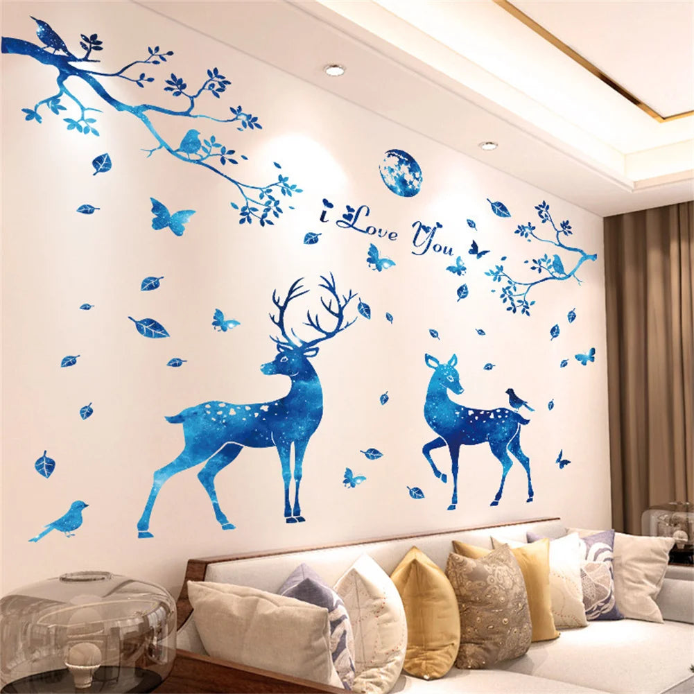 Blue watercolor wall stickers featuring a deer silhouette and floral branches on a white wall.