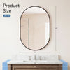 Oval wall mirror with a black metal frame mounted above a marble vanity countertop.