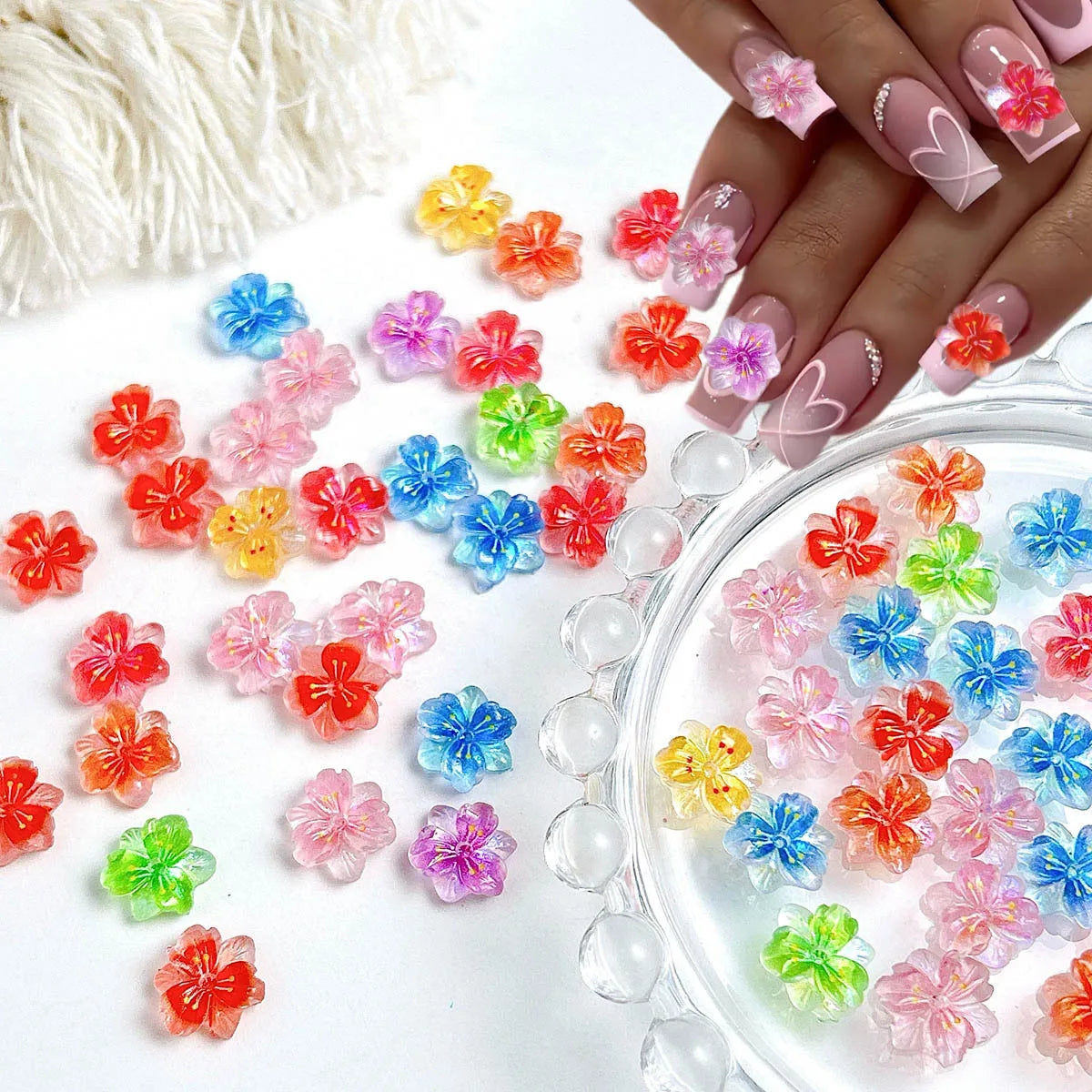 A collection of colorful 3D resin ladybug nail art charms in various shades displayed on a clear glass dish.