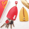 A red and yellow cartoon PU leather key holder with a pull-out design and a gold leaf accent.