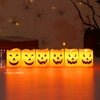 A set of six orange Halloween LED candle lights shaped like jack-o'-lanterns arranged in a row.