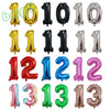 A collection of rose gold, black, silver, and pink foil number balloons for birthday party decor.