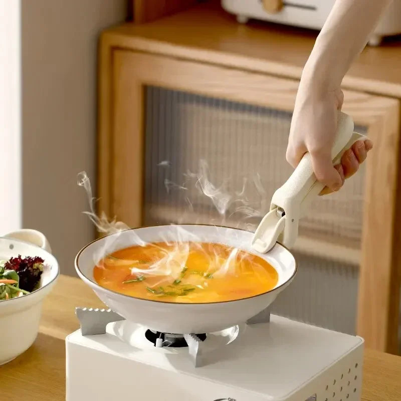 A hand is pouring orange liquid into a bowl on a heating device, creating steam above the liquid.