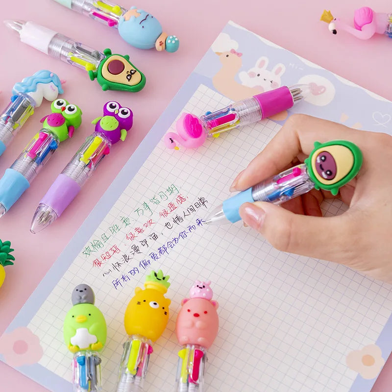A hand holds a set of five cute cartoon mini ballpoint pens in various colors and designs on a white grid paper.