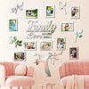 A wall collage featuring framed photos and leaves arranged in the shape of a family tree, with pink upholstered chairs in the