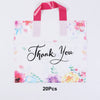 A white floral thank you gift bag with pink ribbon and watercolor flowers.