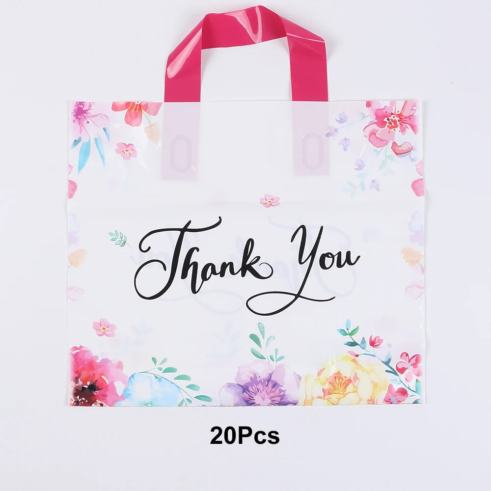 A white floral thank you gift bag with pink ribbon and watercolor flowers.