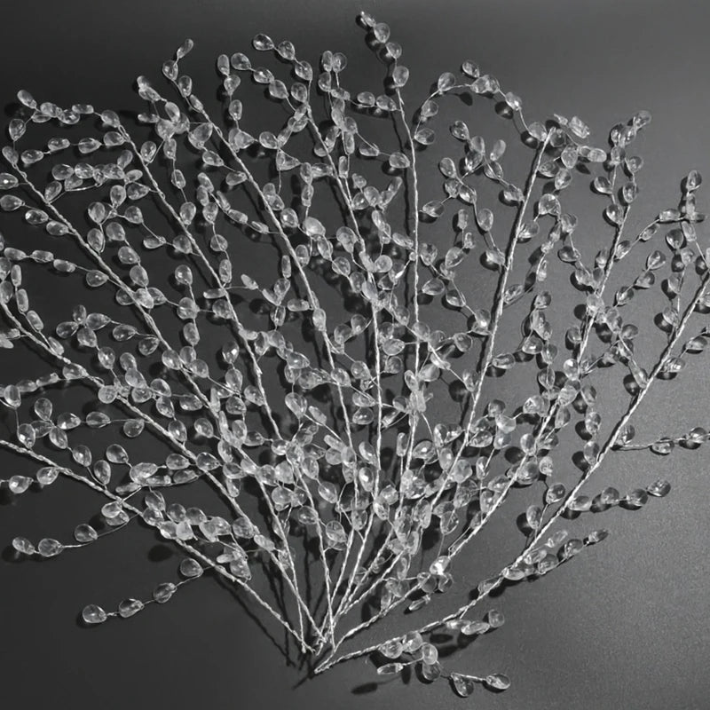 A delicate spray of clear crystal acrylic pendant ornaments arranged on a dark gray background.