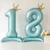 A large blue foil number balloon shaped like the number 18 with gold crown toppers.