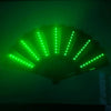 An illuminated folding hand fan with LED lights, showing green light radiating from the center.