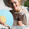 A woman smiling while holding an elegant paper folding fan for women performance