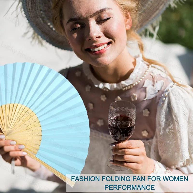 A woman smiling while holding an elegant paper folding fan for women performance