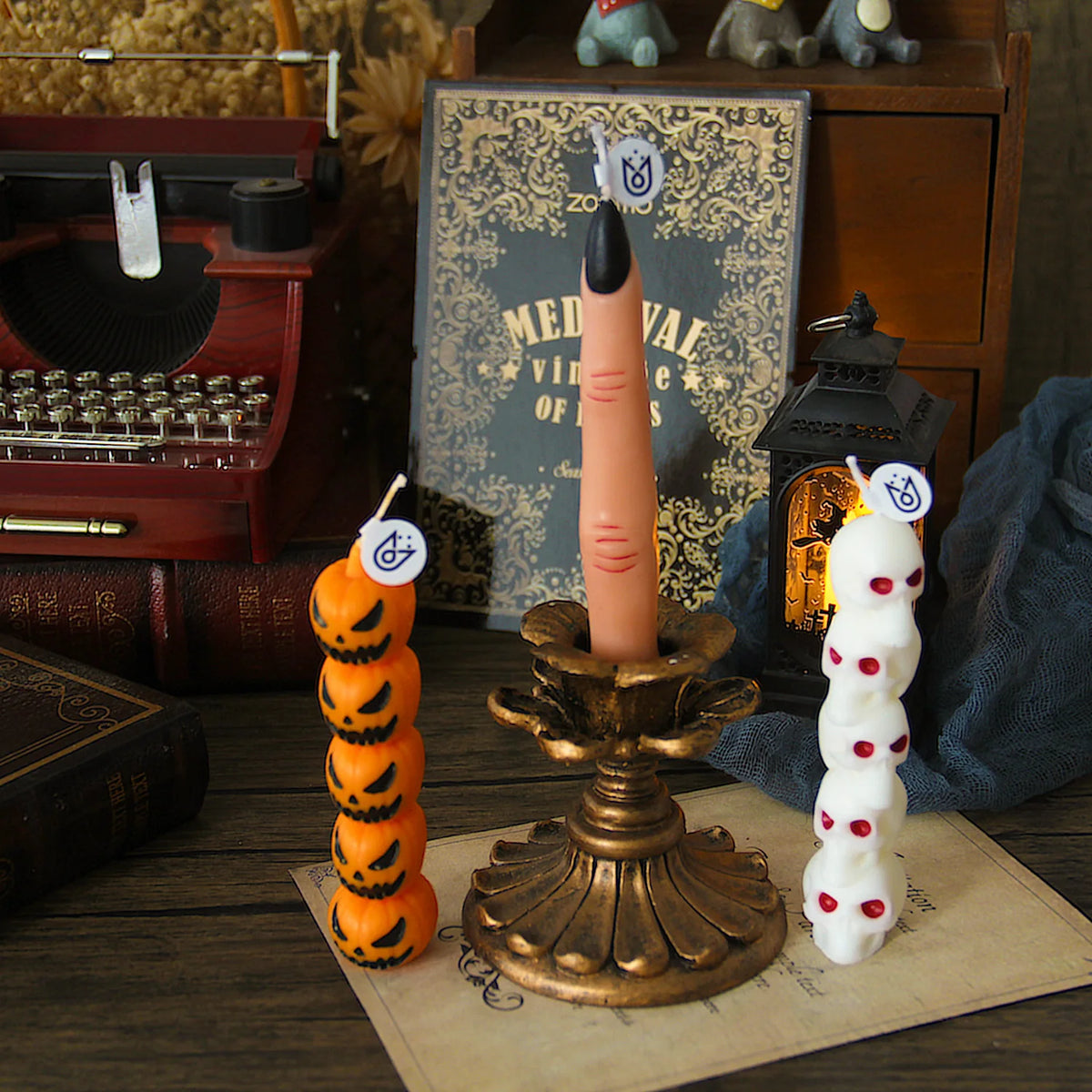 A tall orange candle shaped like a skull and skeleton sits on an antique brass oil lamp.