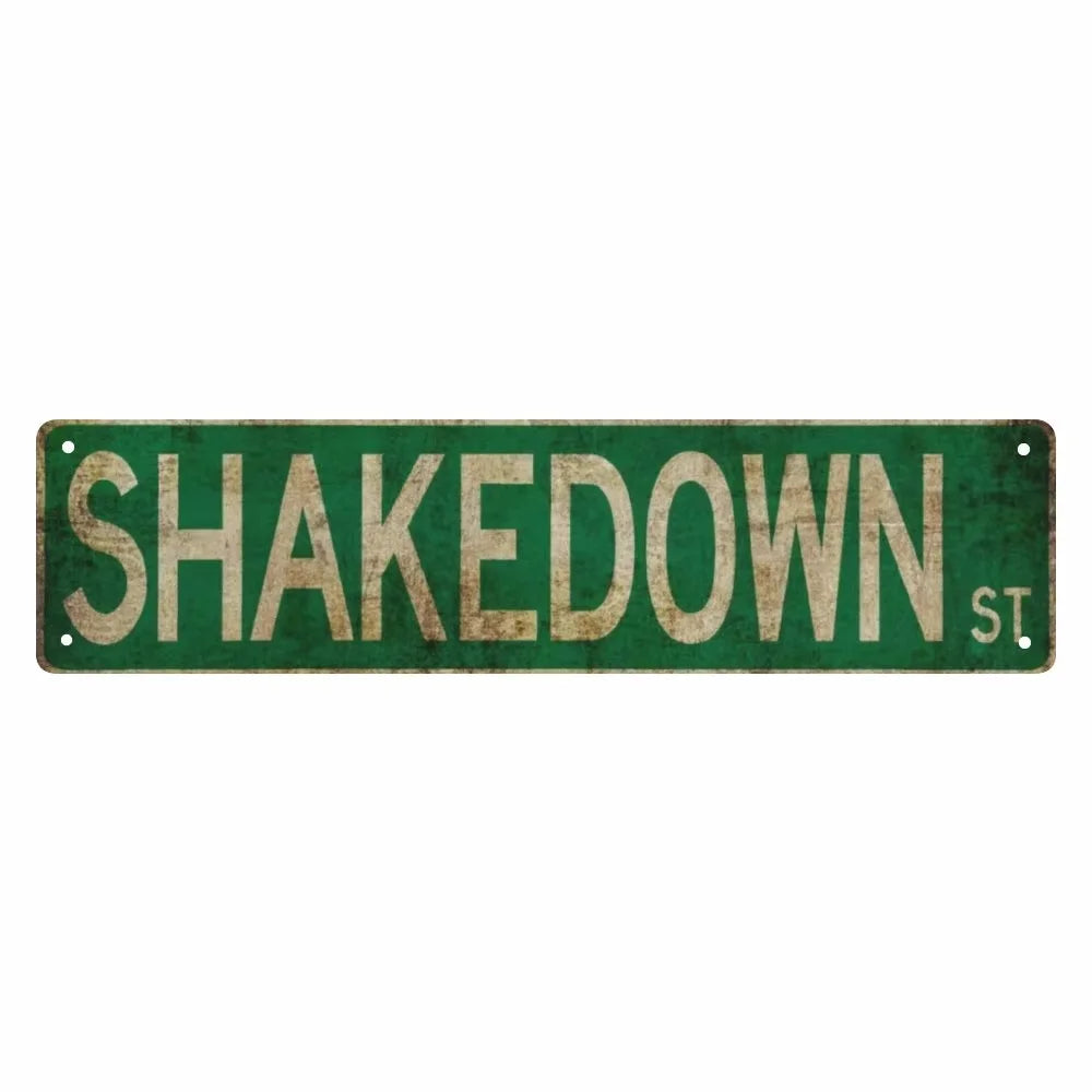A vintage green metal street sign with the text SHAKEDOWN St.