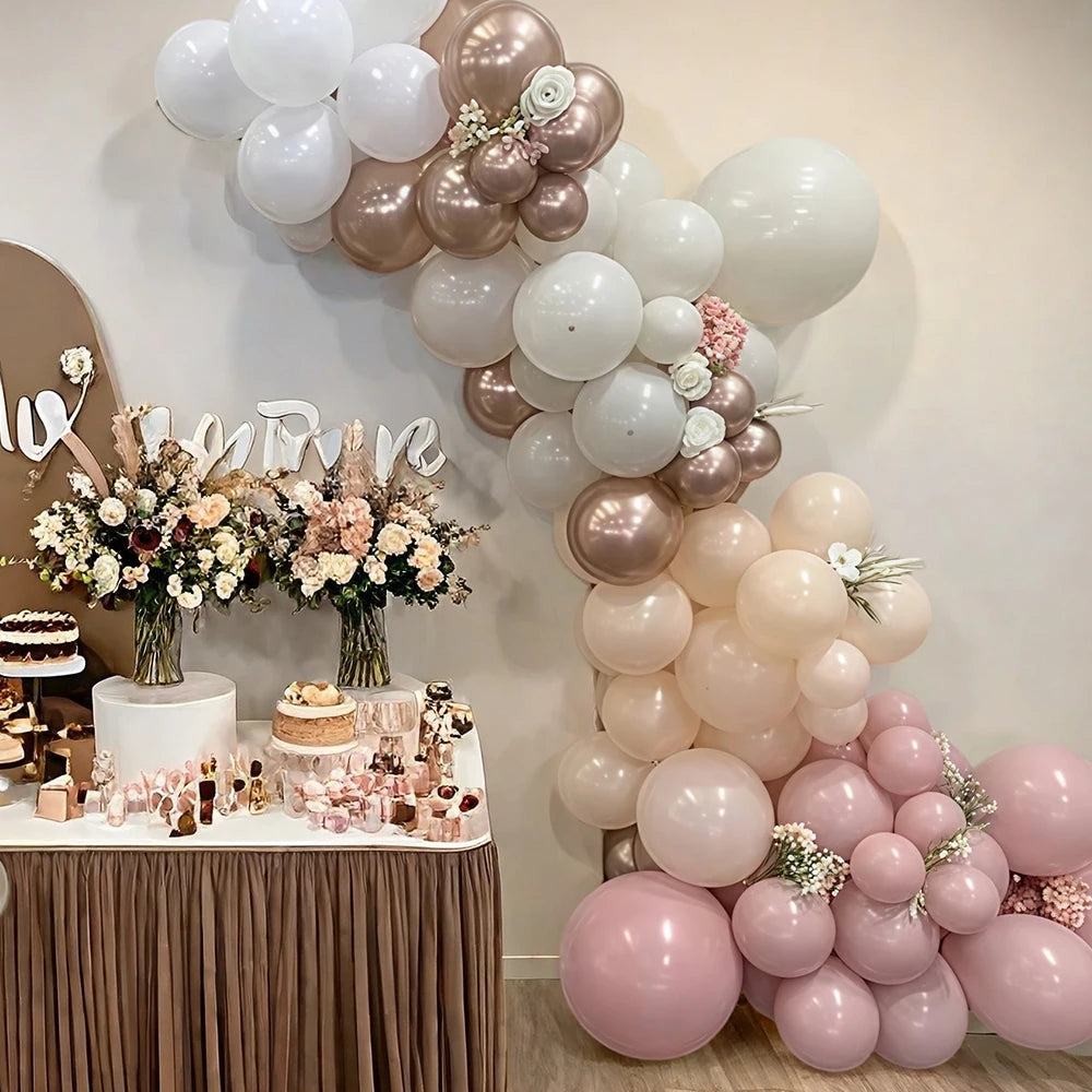 A display of pink, sand, and gold balloons arranged in a cascade for a celebration decor