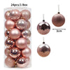 A box containing 24 festive Christmas tree ornament balls in various shades of rose gold and bronze.