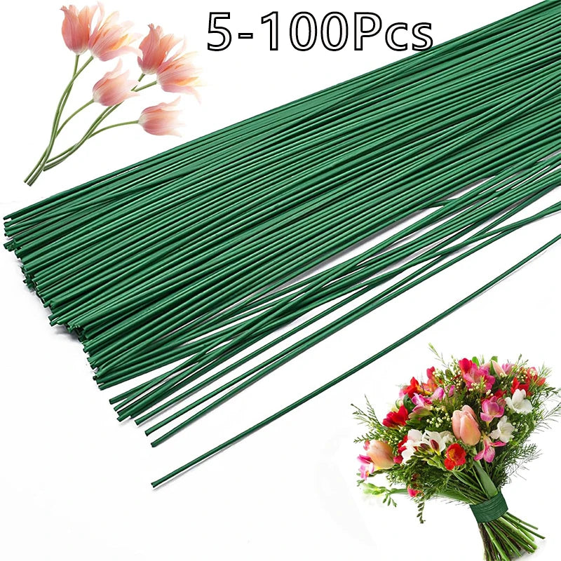 A bundle of flexible green floral wire stems, ranging from 5 to 100 pieces, laid out diagonally with a finished floral arrang